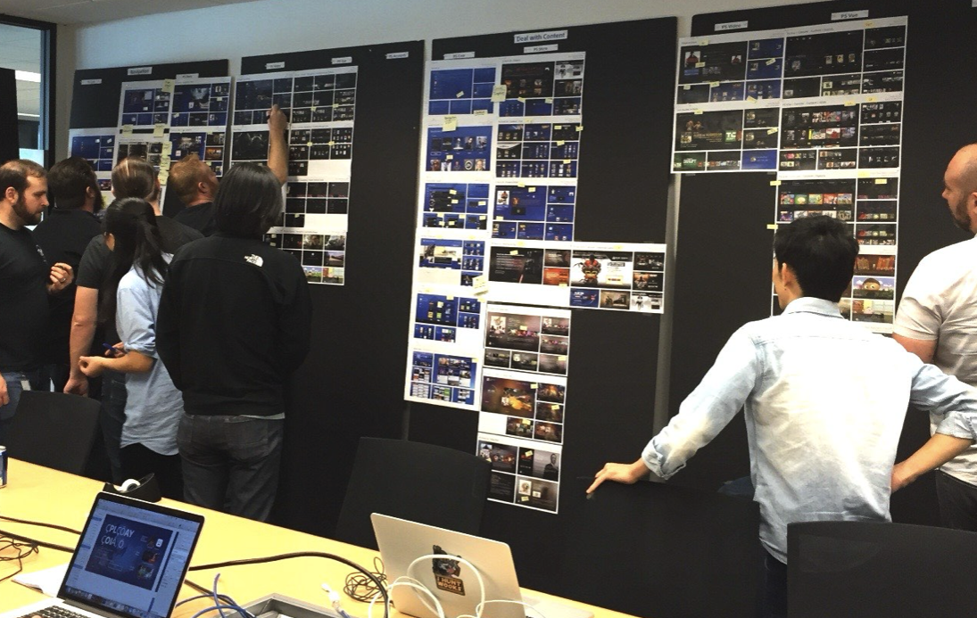 Designers reviewing navigation and content concepts during a wall critique