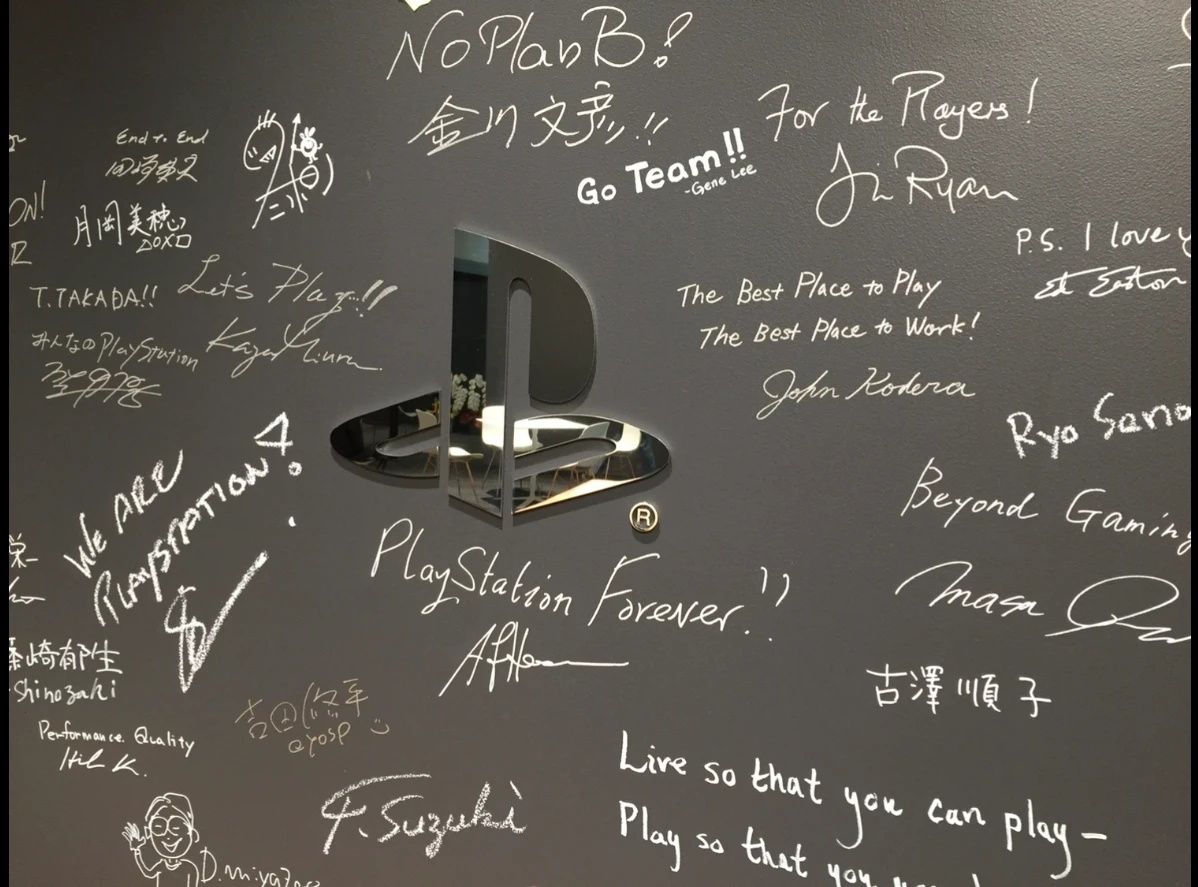 PlayStation office family wall — handwritten team messages around the PlayStation logo